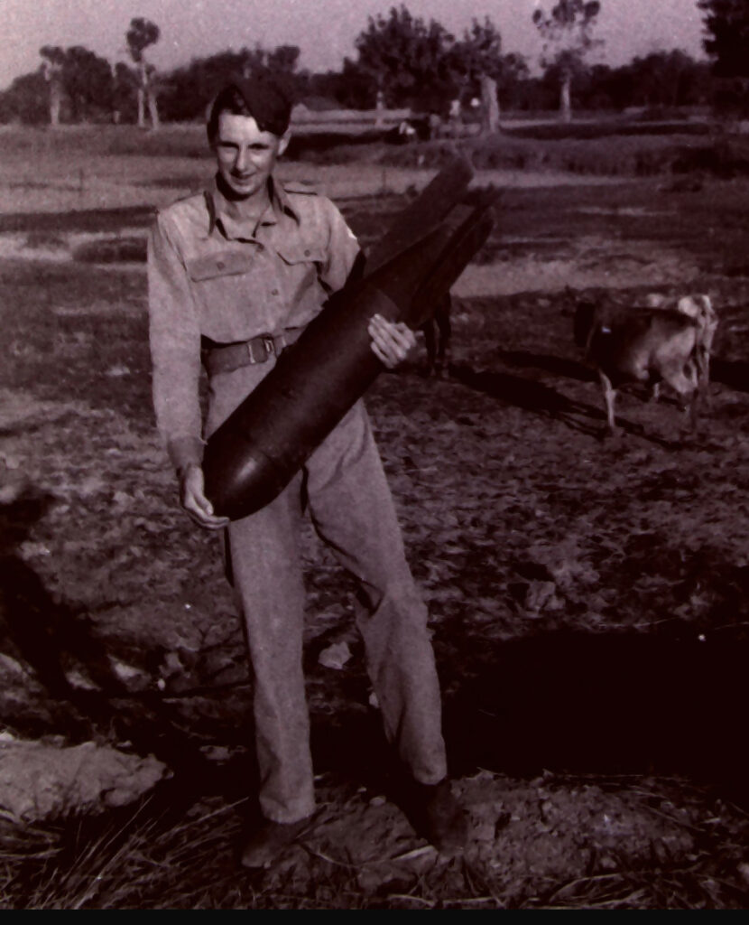 Eric McDonnell at Karnafuli near Chittagong 1943 holding an unexploded Japanese bomb
